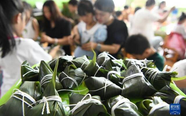 ▲6月19日，在河北省邯郸市广平县第四幼儿园，小朋友在家长的帮助下学习包粽子。图/新华社