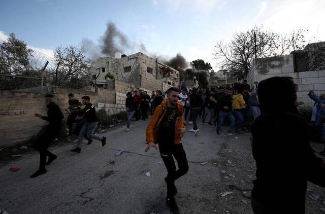 3月7日，巴勒斯坦人在约旦河西岸北部城市杰宁与以色列军队冲突中奔跑躲避。新华社发（艾曼·努巴尼摄）