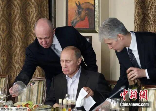 2011年11月11日，俄罗斯莫斯科郊外的一家餐厅，普里戈任（左）在为普京（中）上菜。