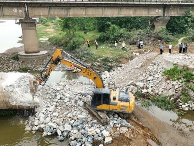 在检察官和相关部门工作人员的监督下,废弃铁路桥墩正在有序地进行拆除。