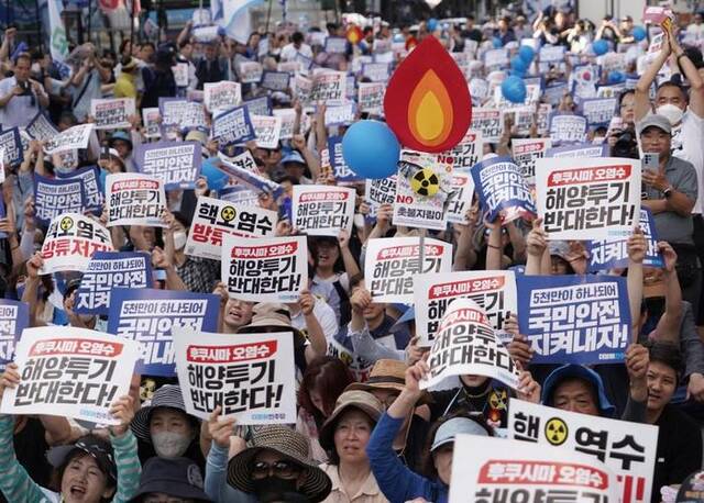 7月1日，民众手持“反对向海洋排放福岛核污染水”等字样的标语在韩国首尔参加集会。新华社发李相浩摄