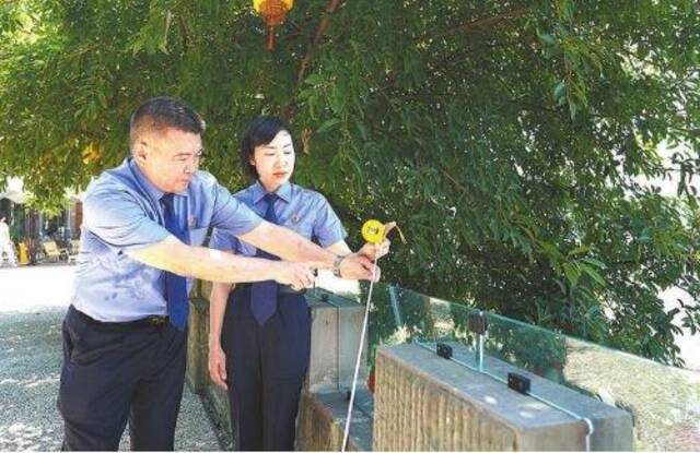 重庆市渝中区检察院检察官对仁爱荒野公园临崖护栏安全整改项目进行“回头看”,检查护栏高度。
