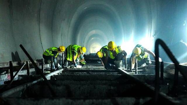 7月8日，滇藏铁路丽香段哈巴雪山隧道内，建设者进行无砟道床施工。（新华社记者丁怡全摄）