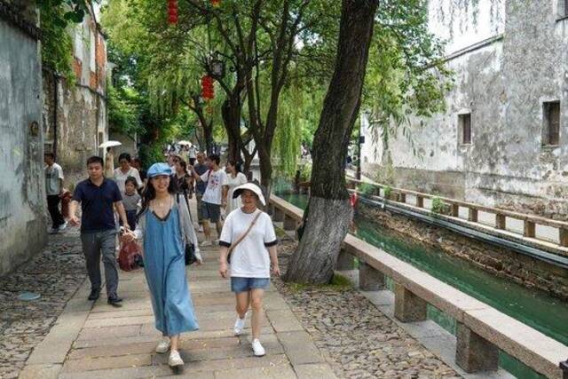 7月6日，游客在平江历史文化街区休闲游玩。