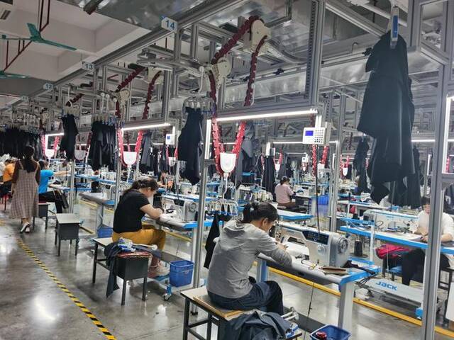 玉林佳都服装集团有限公司的生产车间内，工人们忙着生产服装。新华社记者黄庆刚摄