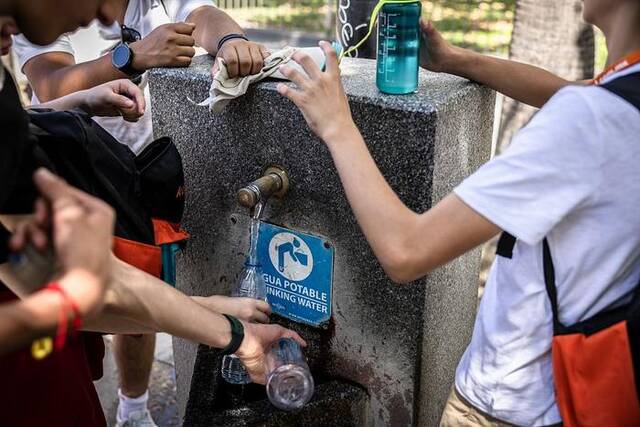 当地时间2023年7月5日，西班牙塞维利亚，高温天气下，市民游客们都在往水杯中补水。