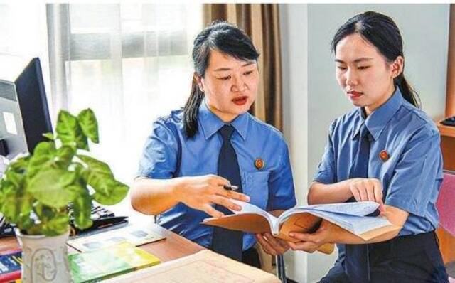 张雪情(左)和同事讨论行政非诉执行监督案件。