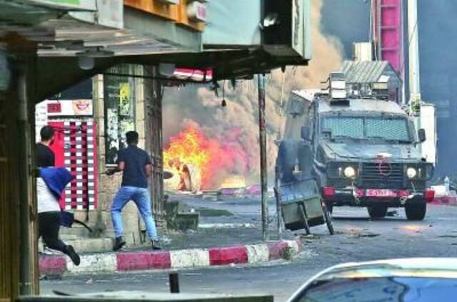 7月4日，在约旦河西岸杰宁地区，巴勒斯坦抗议者同以色列军队发生冲突。新华社发