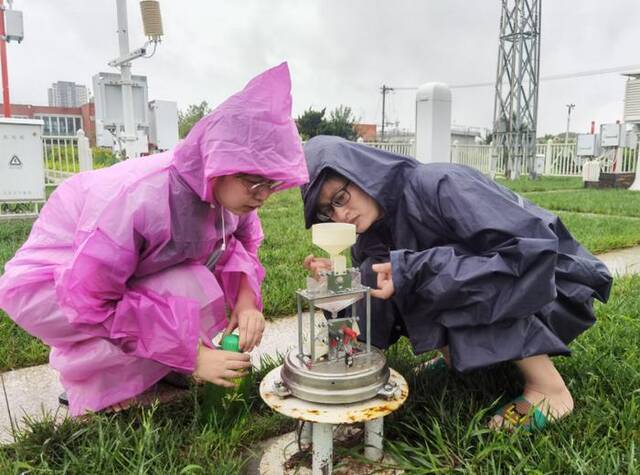 7月30日上午，朝阳区气象局业务人员加强翻斗雨量传感器维护。林鹏摄