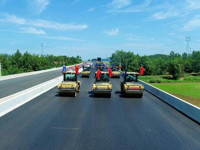 7月10日，武汉至阳新高速公路陈贵互通路段，智能无人化摊铺设备正在作业。（王鹏摄）