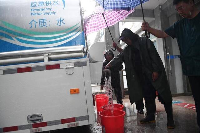 7月31日傍晚，门头沟区上岸疗养院工作人员在应急供水车处取水。新华社记者鞠焕宗摄