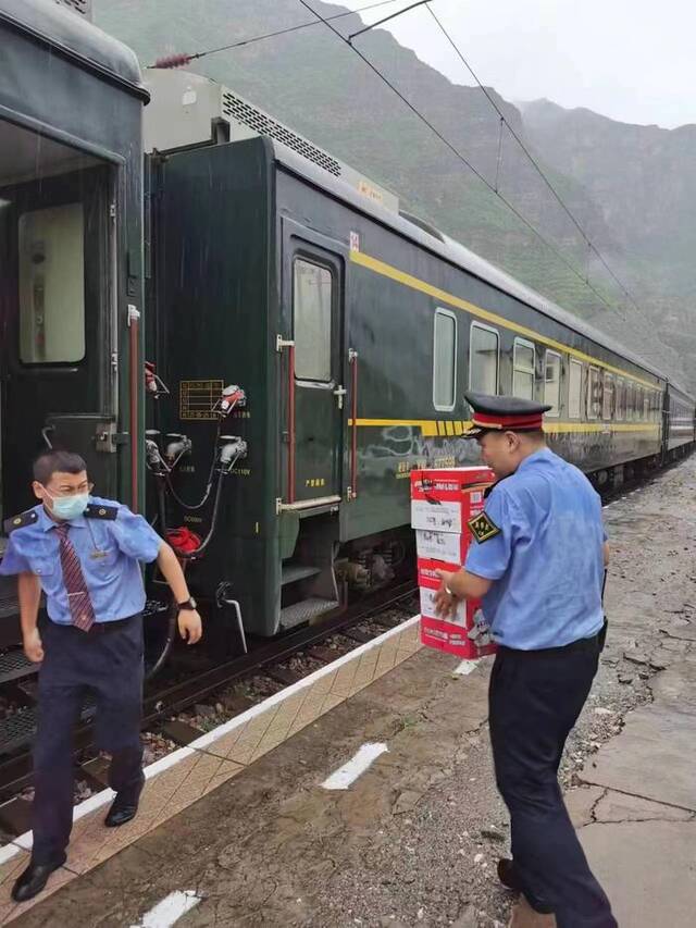 铁路部门为滞留列车上的旅客配送必要的生活物资。中国铁路北京局供图