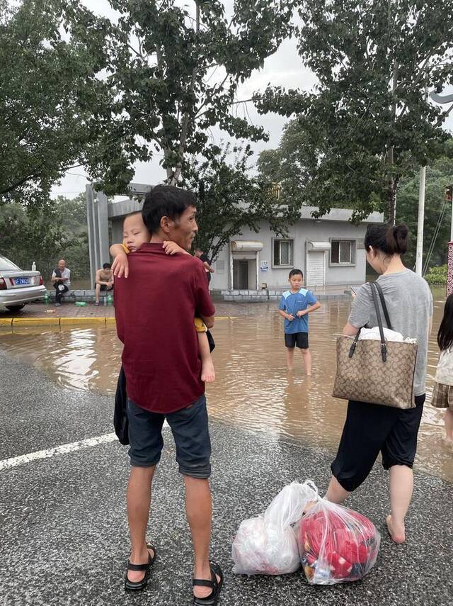 陈康抱着孙子，等待转运至安全地带。澎湃新闻记者陈媛媛摄