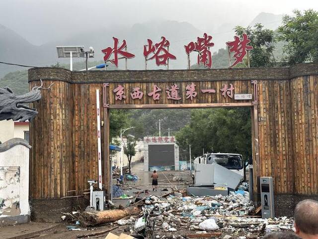 8月1日，水峪嘴村门口堆积了大量被洪水冲坏的物品。新京报记者慕宏举摄