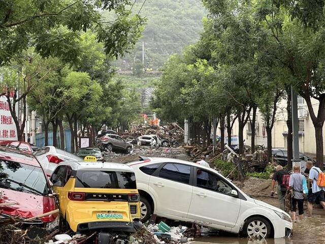 8月1日，水峪嘴村内多辆汽车被冲毁。新京报记者慕宏举摄