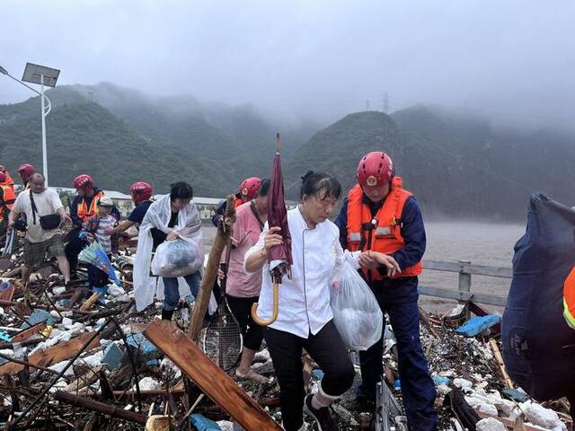 8月1日，消防救援人员转移、救助水峪嘴村村民。图源：门头沟区消防救援支队