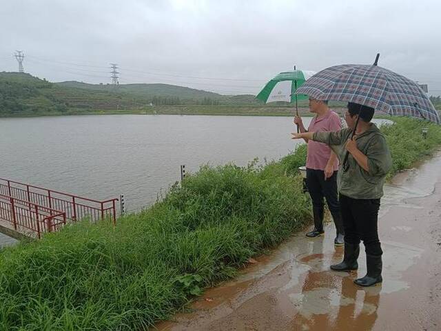 图为秦皇岛市卢龙县双望镇纪检监察干部到向阳水库查看堤坝、水库水位标识情况。