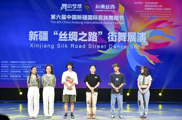 7月21日，古扎努尔·吐尔达洪（左一）和其他青年街舞演员一起在舞台上讲述学舞故事。新华社记者胡虎虎摄
