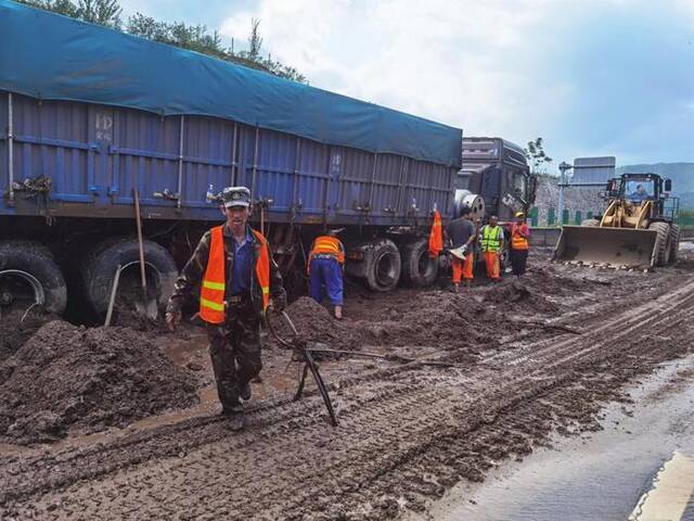 8月2日，工人在清理受困车辆底部的淤泥。新华社记者冯维健摄