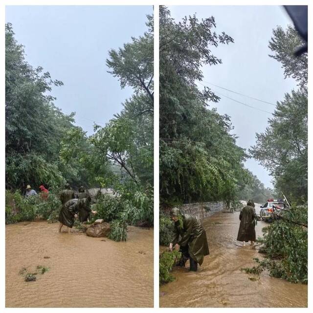 7月31日下午,检察干警在救援途中顶着暴雨清理因山体滑坡堆积在道路上的树木和石头。(摄影:王维福)