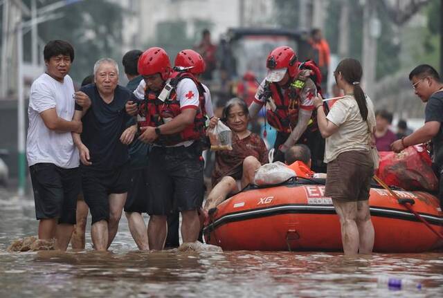 8月3日，涿州团结小区外，红十字会救援人员营救出被困民众。新京报记者陶冉摄