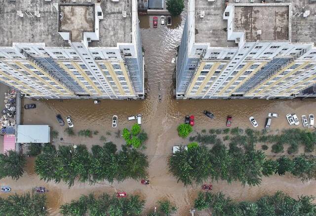 8月3日，涿州北二环路一小区内，不少车辆被洪水淹没。新京报记者陶冉摄