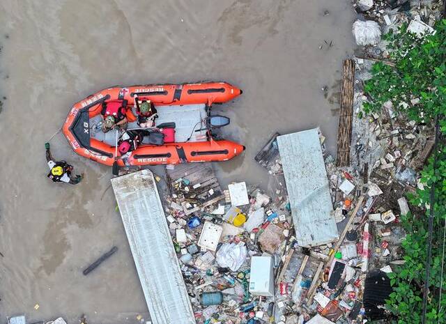 8月3日，涿州107国道附近，红十字会救援人员下水清理挡住皮划艇救援航路的水域。新京报记者陶冉摄