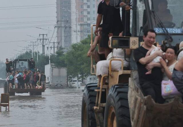 8月3日，107国道涿州段，志愿者用重型车辆将受困居民转移到安全位置。新京报记者陶冉摄