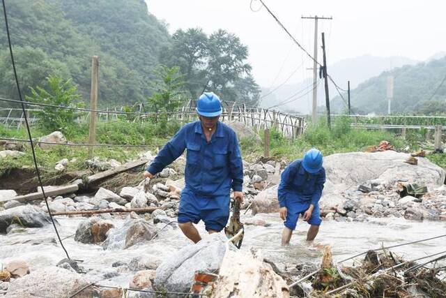 国网灵寿县供电公司抢修人员涉水前往10千伏654漫山线抢修现场。（受访单位供图）