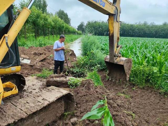 7月29日，张海英找师傅挖开排水沟。受访者供图