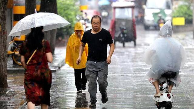 2023年8月7日，西安，市民冒雨出行。视觉中国图