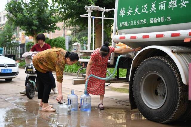 8月4日，河北省涿州市新星小区居民从供水车里接水。