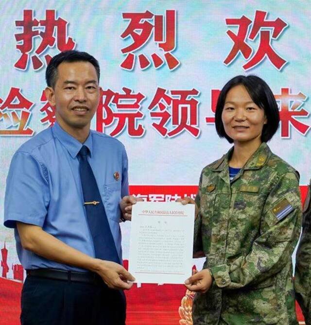 广东省湛江市检察院检察长张和林向全国人大代表王亚茹(右)呈送最高检贺信。