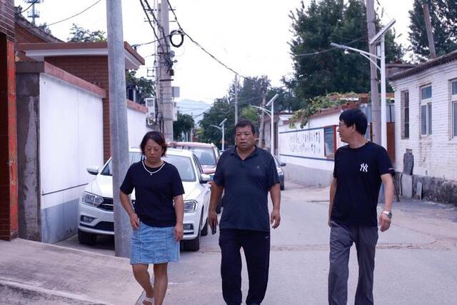 8月4日，暴雨过后，北白岱村党支部书记贾忠慧和村干部一起查看村里排水情况。新京报记者曹晶瑞摄