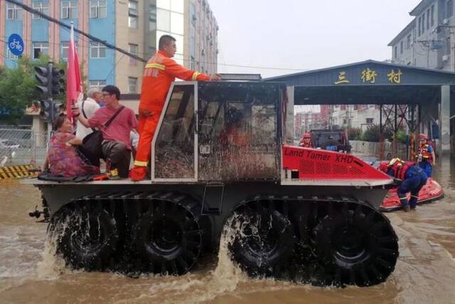 国网北京电力工程公司应急救援队队员在抢修途中帮助受困群众转移
