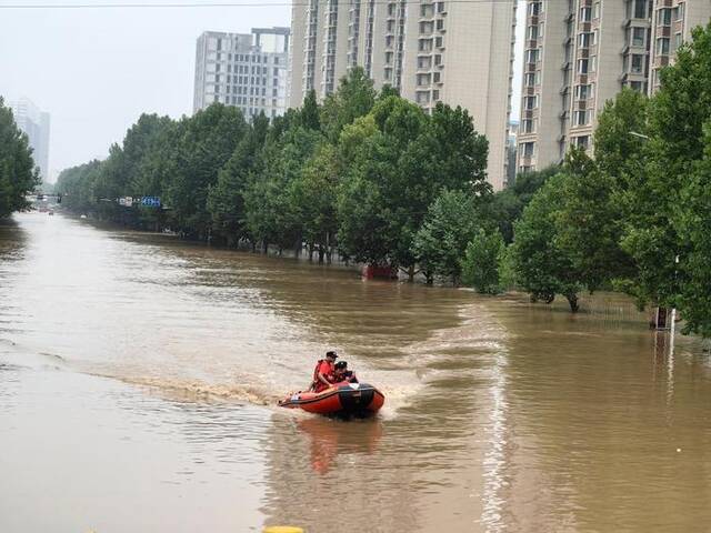 救援人员在涿州市内乘冲锋舟救援转移群众。新华社记者高博摄