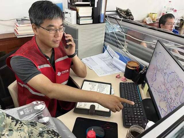 北京联通门头沟分公司网络部经理郑铮在研究门头沟通信抢修“作战图”。受访者供图