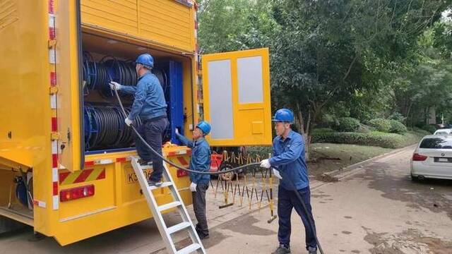 8月6日，国网山东省电力公司潍坊市寒亭区供电公司的丁心（右一）与同事在河北涿州瑞卓天伦湾小区接通电力。受访者供图