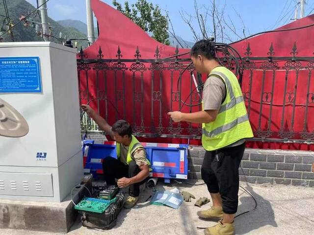 8月8日，北京联通施工人员在北京门头沟区安家庄村紧急抢通受损的通信线路。（受访者供图）