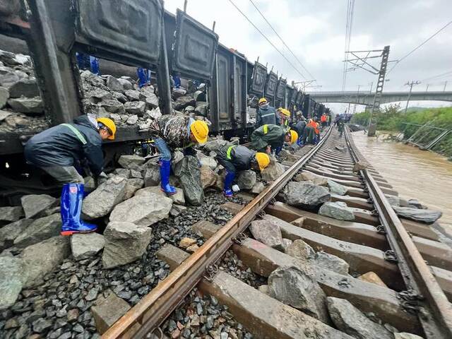 中铁二十二局一公司抢险人员在黑龙江省尚志市滨绥铁路水害路段运卸块石，填补加固塌方处路基。