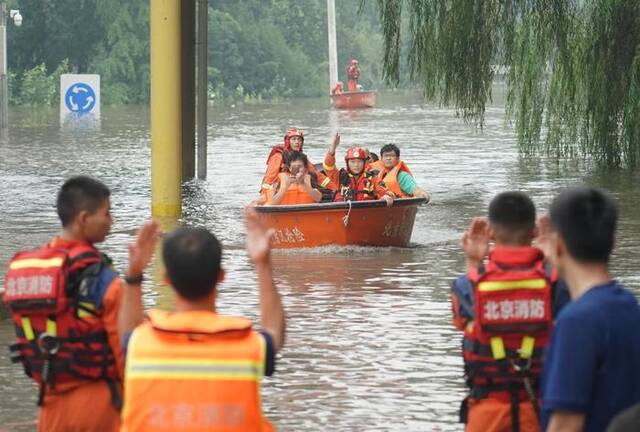 8月2日，在北京市房山区的京港澳高速琉璃河出口，受灾群众乘坐冲锋舟前往转运车辆乘车点。新华社记者任超摄