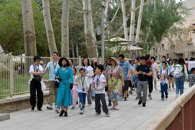 8月9日，游客在讲解员的带领下在莫高窟参观游览。新华社记者范培珅摄