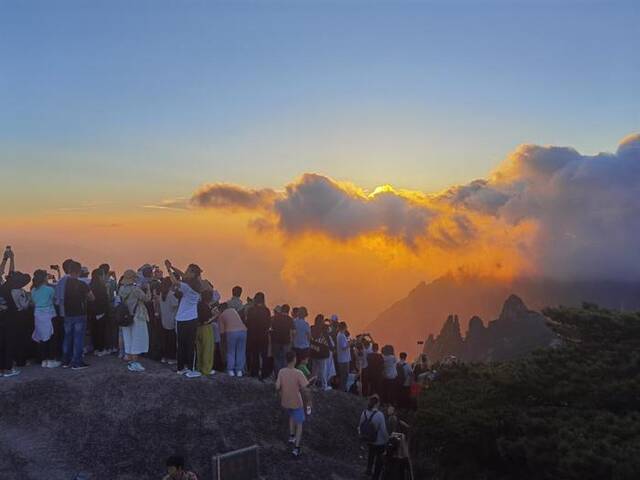 游客正在黄山上观看日出。（资料图）