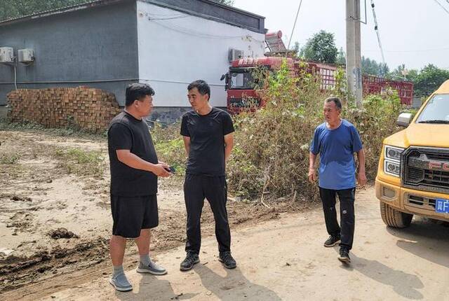 8月9日，望海庄村党支部书记杨黎颖（左一）和刁窝镇党委书记张大众（左二）在村口商议恢复供电事宜。新华社记者苏凯洋摄