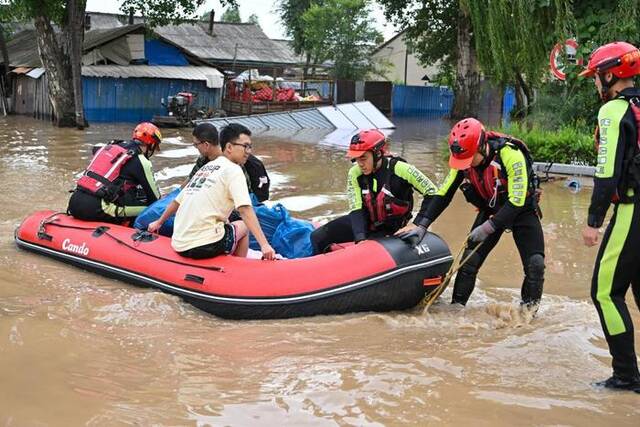 8月5日，哈尔滨森林消防支队的消防员在黑龙江省哈尔滨市延寿县转移受困群众。新华社记者陈益宸摄