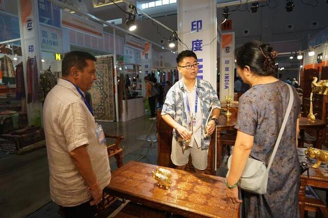 8月18日，翻译人员（中）在印度展位为来访的客户介绍产品。新华社记者陈欣波摄