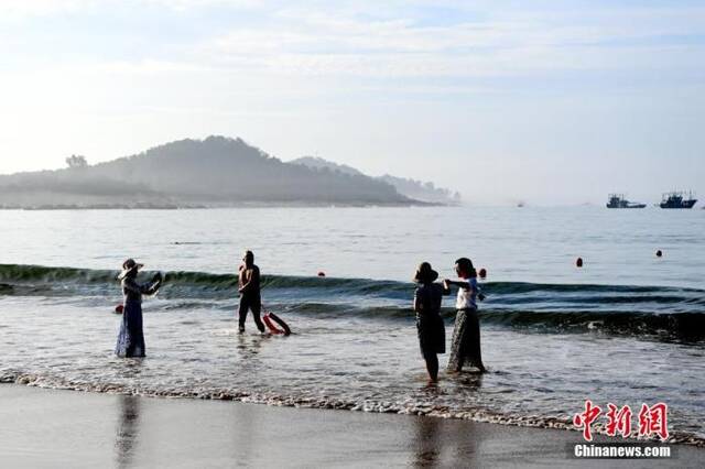 资料图：游客在海边拍照打卡。张金川摄