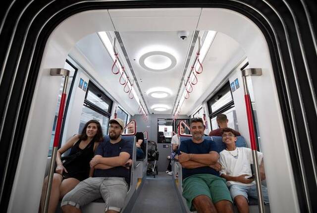 8月18日，在以色列城市特拉维夫，人们搭乘轻轨红线列车。（新华社记者陈君清摄）