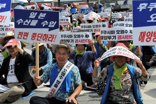 8月16日，在韩国全罗南道高兴郡沿海一带，韩国渔民手持标语参加集会活动，抗议日本核污染水排海计划。新华社记者周思雨摄