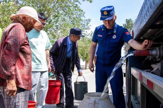 8月15日，张掖市森林消防支队为山丹县干旱缺水地区群众送水。（张掖市森林消防支队供图）